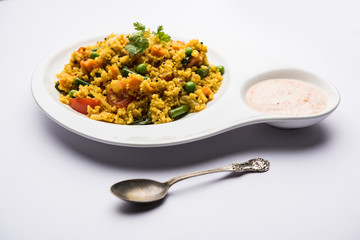 Broken wheat or Daliya Upma, served in a bowl. selective focus