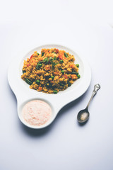 Broken wheat or Daliya Upma, served in a bowl. selective focus