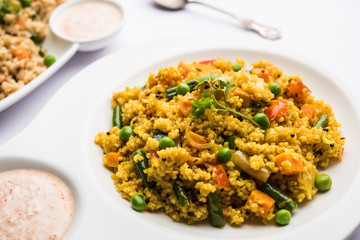 Broken wheat or Daliya Upma, served in a bowl. selective focus