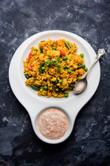Broken wheat or Daliya Upma, served in a bowl. selective focus