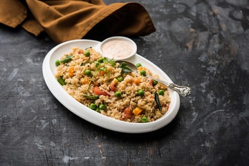 Broken wheat or Daliya Upma, served in a bowl. selective focus