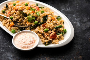 Broken wheat or Daliya Upma, served in a bowl. selective focus