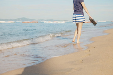 Asian woman walking on the beach