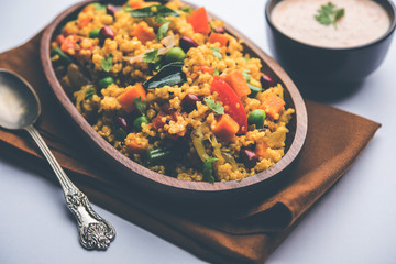 Broken wheat or Daliya Upma, served in a bowl. selective focus
