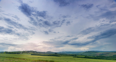 Meadow landscape with dramatic blue sky and clouds