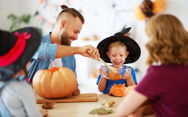 Fototapeta premium happy Halloween! family mother father and children cut pumpkin for holiday at home..