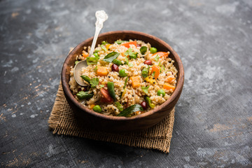 Broken wheat or Daliya Upma, served in a bowl. selective focus