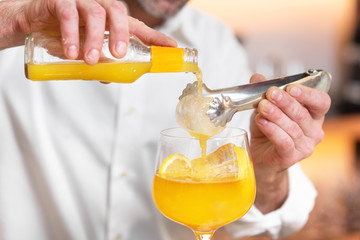 Expert barman is making cocktail at night club.