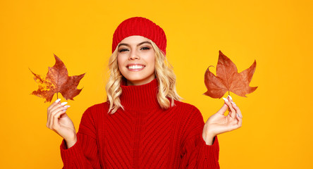  happy emotional cheerful girl laughing  with knitted autumn red cap  on colored yellow background.