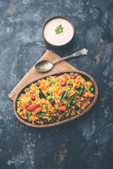 Broken wheat or Daliya Upma, served in a bowl. selective focus