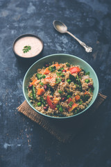 Broken wheat or Daliya Upma, served in a bowl. selective focus