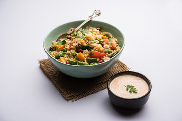Broken wheat or Daliya Upma, served in a bowl. selective focus