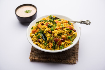 Broken wheat or Daliya Upma, served in a bowl. selective focus