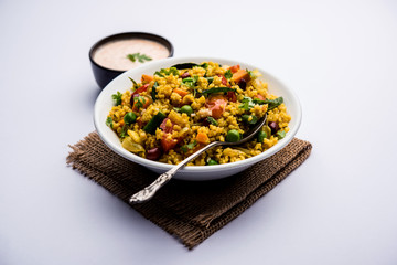 Broken wheat or Daliya Upma, served in a bowl. selective focus
