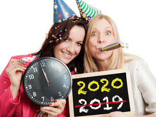 Two women holding a chalkboard and a clock isolated on white background. New year 2020 concept.