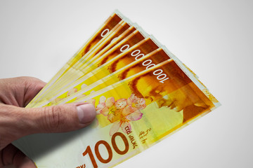 Hand holding Israeli shekels. ILS. Money of Israel.