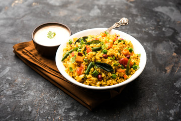 Broken wheat or Daliya Upma, served in a bowl. selective focus