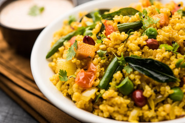 Broken wheat or Daliya Upma, served in a bowl. selective focus