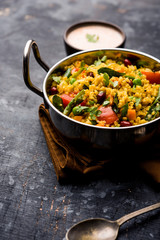 Broken wheat or Daliya Upma, served in a bowl. selective focus