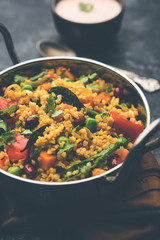 Broken wheat or Daliya Upma, served in a bowl. selective focus