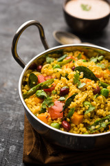 Broken wheat or Daliya Upma, served in a bowl. selective focus