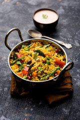 Broken wheat or Daliya Upma, served in a bowl. selective focus