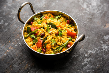 Broken wheat or Daliya Upma, served in a bowl. selective focus