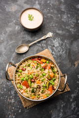 Broken wheat or Daliya Upma, served in a bowl. selective focus