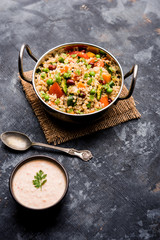 Broken wheat or Daliya Upma, served in a bowl. selective focus