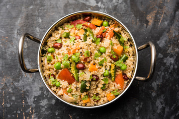 Broken wheat or Daliya Upma, served in a bowl. selective focus