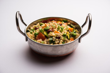 Broken wheat or Daliya Upma, served in a bowl. selective focus