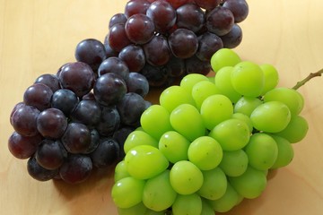 Green grapes and black grapes on the table
