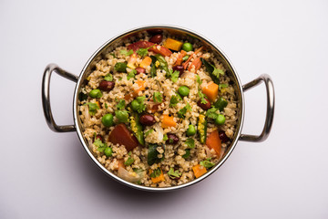 Broken wheat or Daliya Upma, served in a bowl. selective focus