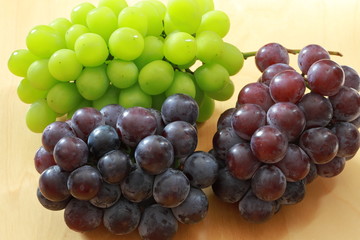 Green grapes and black grapes on the rable