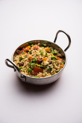 Broken wheat or Daliya Upma, served in a bowl. selective focus