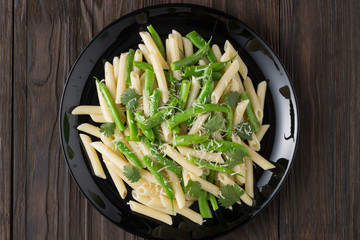 Penne pasta with green beans on a black plate. Restaurant lunch concept, restaurant menu.