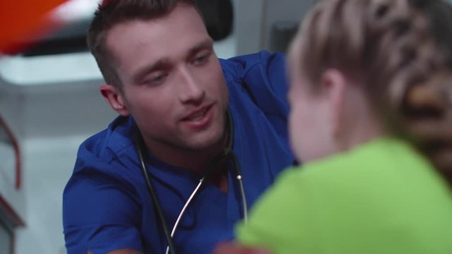 Man in medical uniform talk to little girl.