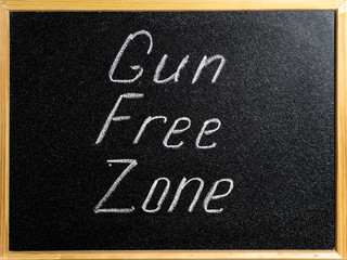 Fototapeta premium Inscription Gun Free Zone in chalk on a school blackboard