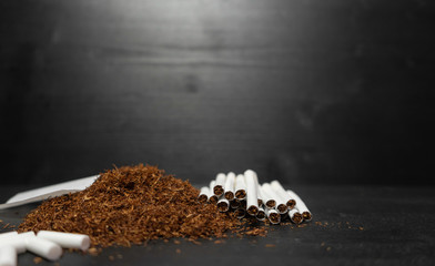 Raw tabaco on black wood background with copy space for text
