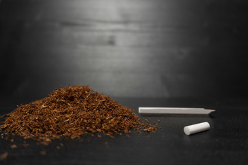 Raw tabaco on black wood background with copy space for text