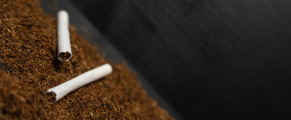 Raw tabaco on black wood background with copy space for text