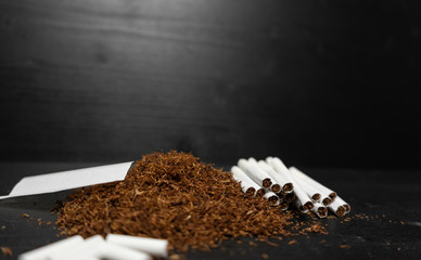 Raw tabaco on black wood background with copy space for text