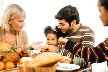 Thanksgiving Celebration Tradition Family Dinner Concept.family having holiday dinner and cutting turkey.Young black adult woman and her daughter happy..