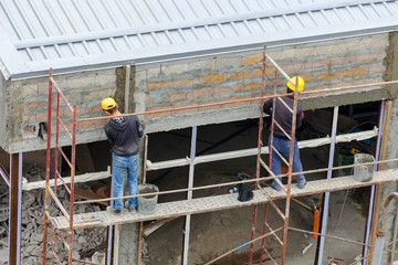 Construction workers plaster wall