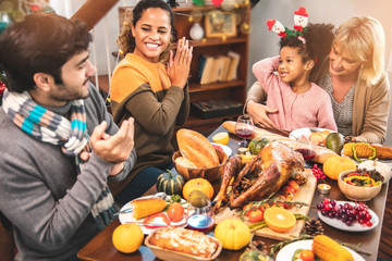 Thanksgiving Celebration Tradition Family Dinner Concept.family having holiday dinner and cutting turkey.Young black adult woman and her daughter happy..