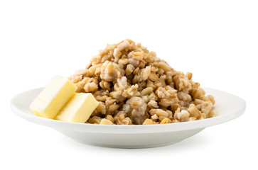 Boiled oatmeal in a plate with butter on a white, isolated.