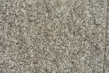 Texture of granite concrete stone wall in sunlight for pattern, background or 3D. Horizontal, close up