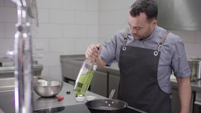 close up of a chef of an upscale restaurant kitchen joyfully indulging in his craft - Close Up des Gesichtes eines K&uuml;chenchefs der mit Freude am Kochen ist in einer gehobenen K&uuml;che