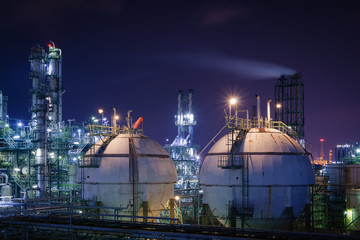 Storage sphere tanks in oil and gas refinery plant with night, Glitter lighting of petrochemical plant, Industrial plant with ultraviolet sky background