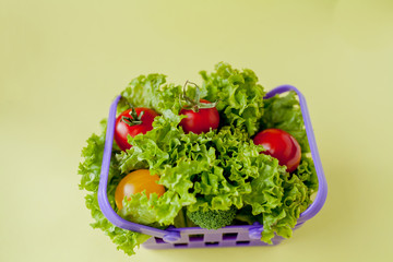 Small Fresh vegetables in basket on yellow background. Food background concept with copyspace